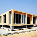 Modern Modular Home Construction**

"A modern, family-friendly modular home being assembled on a construction site in Pakistan. The home is fully clothed in a contemporary design with large windows. Construction workers, fully clothed in appropriate attire, are carefully joining the pre-fabricated sections. Background shows a clear blue sky and a safe urban environment. Perfect anatomy, correct proportions, professional architectural photography, high quality, natural pose, safe for work, appropriate content, fully clothed, professional."

**